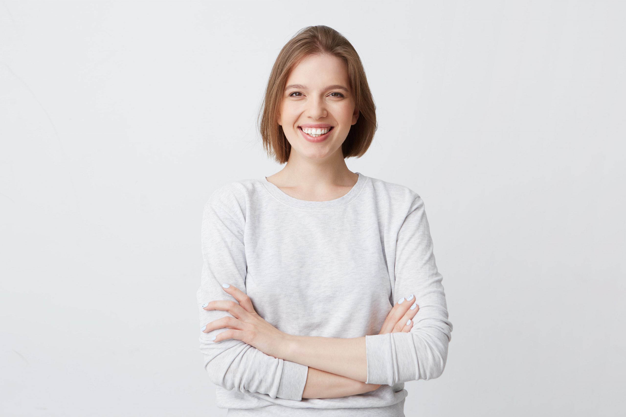 portrait-cheerful-attractive-young-woman-longsleeve-standing-with-arms-crossed-smiling-min